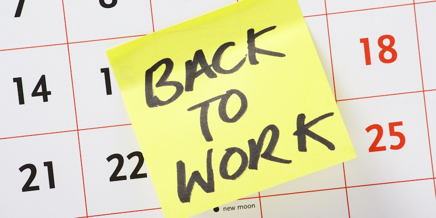a yellow sticky note saying back to work on a calendar