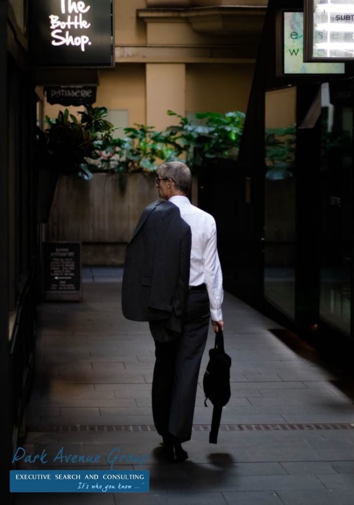a man walking with his suit jacket on his back